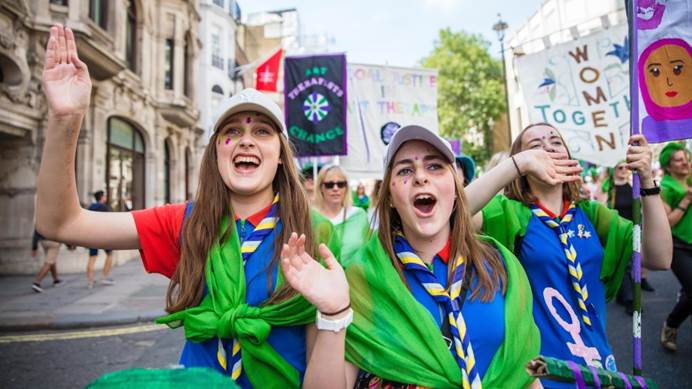 Two Guides cheering and holding banners at the Processions march