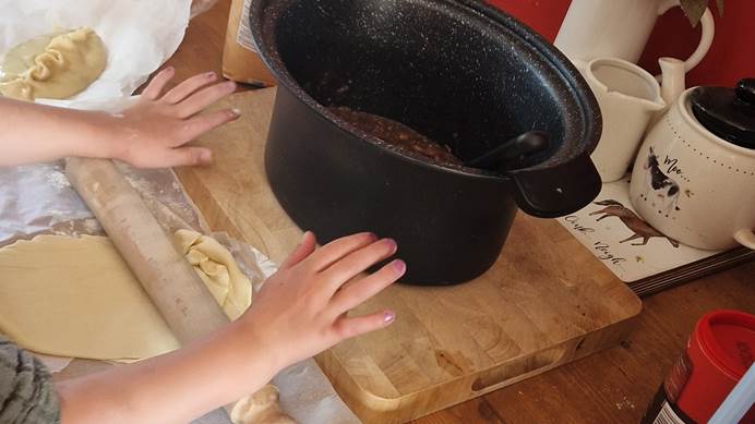 Child rolling out dough with rolling pin