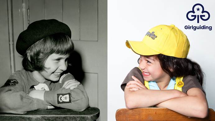 Two Brownies, wearing their uniform, looking at each other and smiling. The first Brownie is from the 70s, the second from the 2020s.