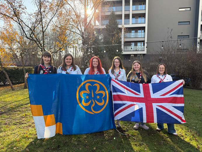 Gemma, Anna, Rowena, Lauren, Emma and Danni with the UK flag and WAGGGS flag.