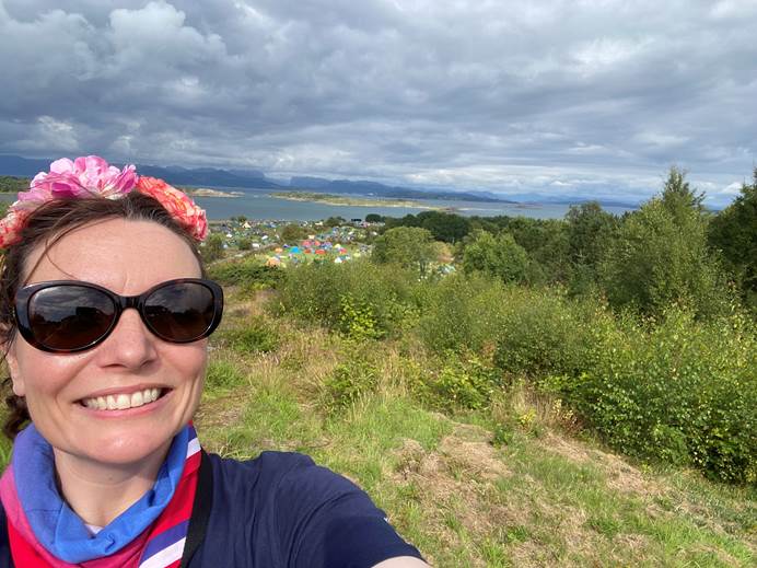 Sally Kettle smiles at the camera with a campsite in the background