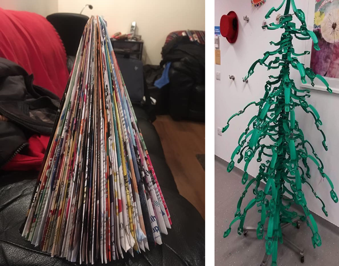 A Christmas tree made from folded magazine pages, and another tree made from a hospital drip stand with painted green branches hanging from it.
