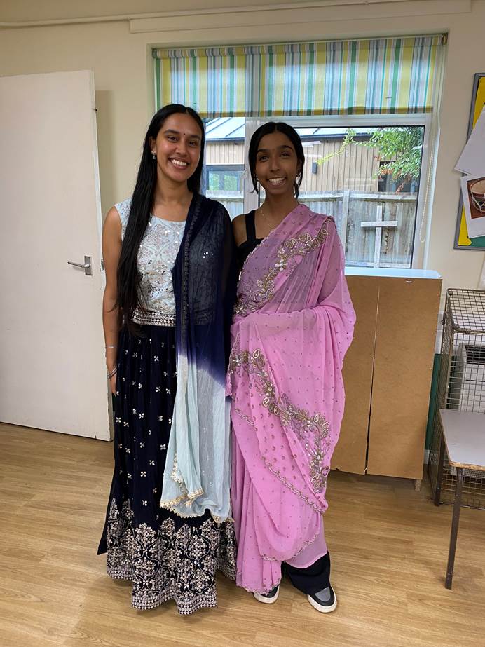 Leaders Ayushi and Peheli dressed in traditional South Asian attire