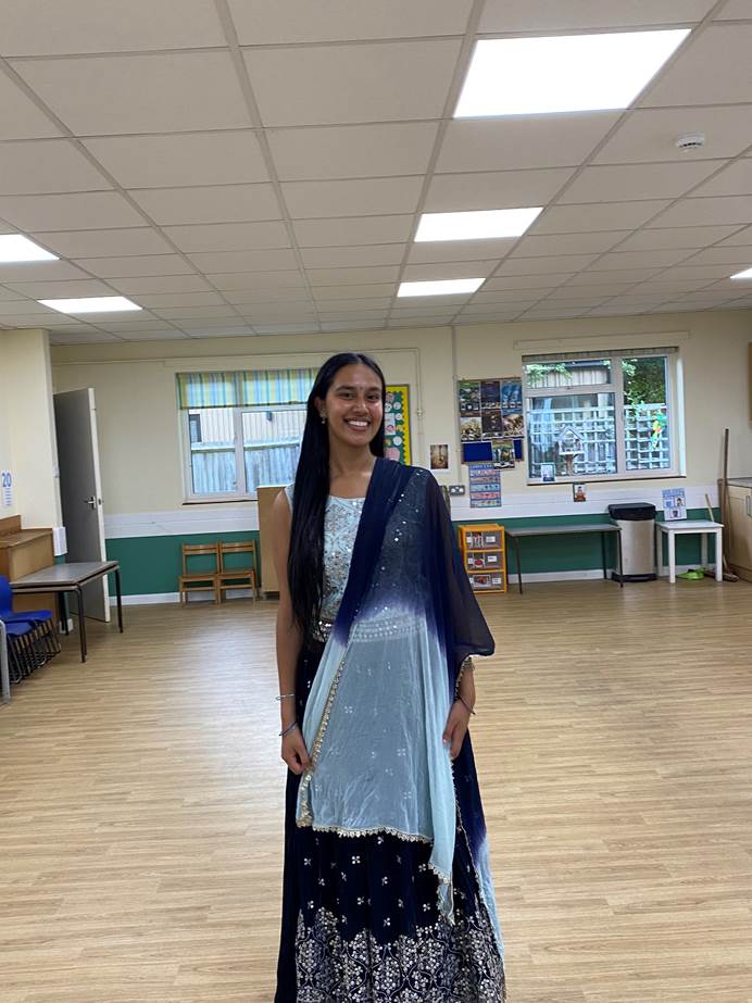 Ayushi, assistant leader smiling in traditional Indian attire