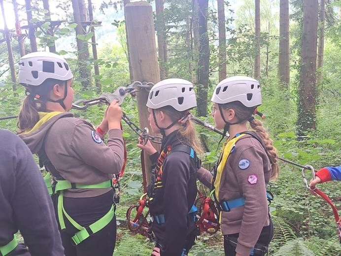 Brownies getting ready to go on the zip wire in safety helmets