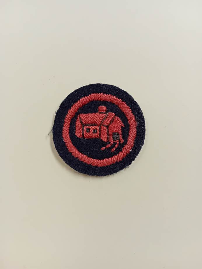 Navy blue black felt with a red embroidered house on the front.