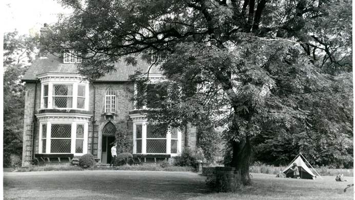 Black and white photo of Glenbrook house with tent pitched outside