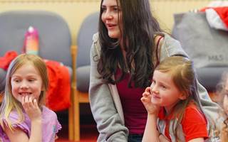 Rainbows and volunteer kneeling on floor