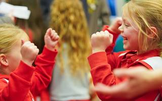 2 children in red jackets smiling