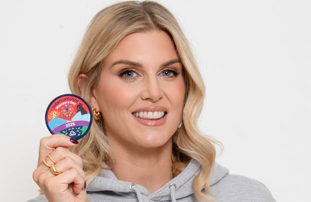 Ashley james holds up an international women's day badge