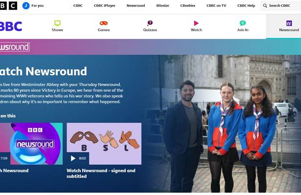 Screenshot of the Newsround homepage which shows an image of two Guides in uniform being interviewed by a presenter in front of Westminster Abbey